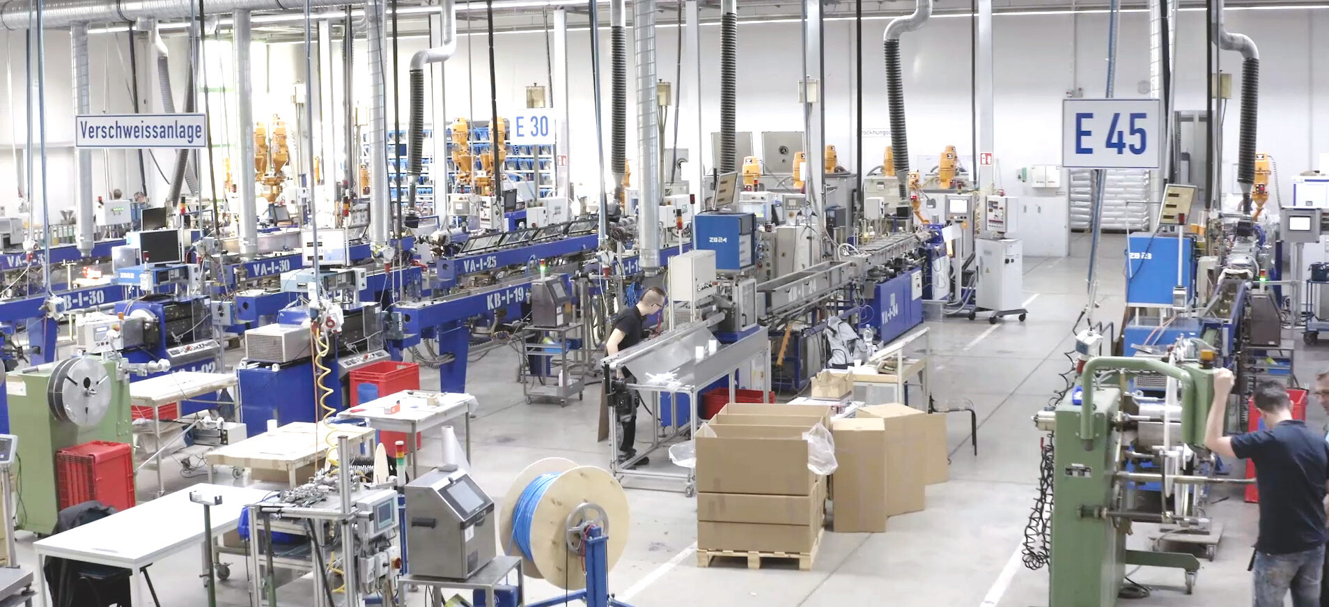 Ein Blick in die Produktionshalle der Novoplast mit diversen Maschinen und Materialien gelagert im Karton. 