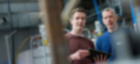 Beispielbild: Mitarbeiter stehen mit einem ipad am Produktionsstandort Gelsenkirchen